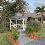 Gazebo painted white with a walkway.