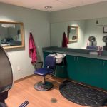 Salon with chair, sink and mirrors.