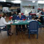 People playing a game at tables in a common area.