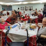 Resident and Staff Holiday Party with people eating.