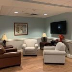 Resident common area in the lobby with chairs and tv.