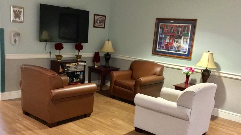 Resident common area in the lobby with chairs and tv.