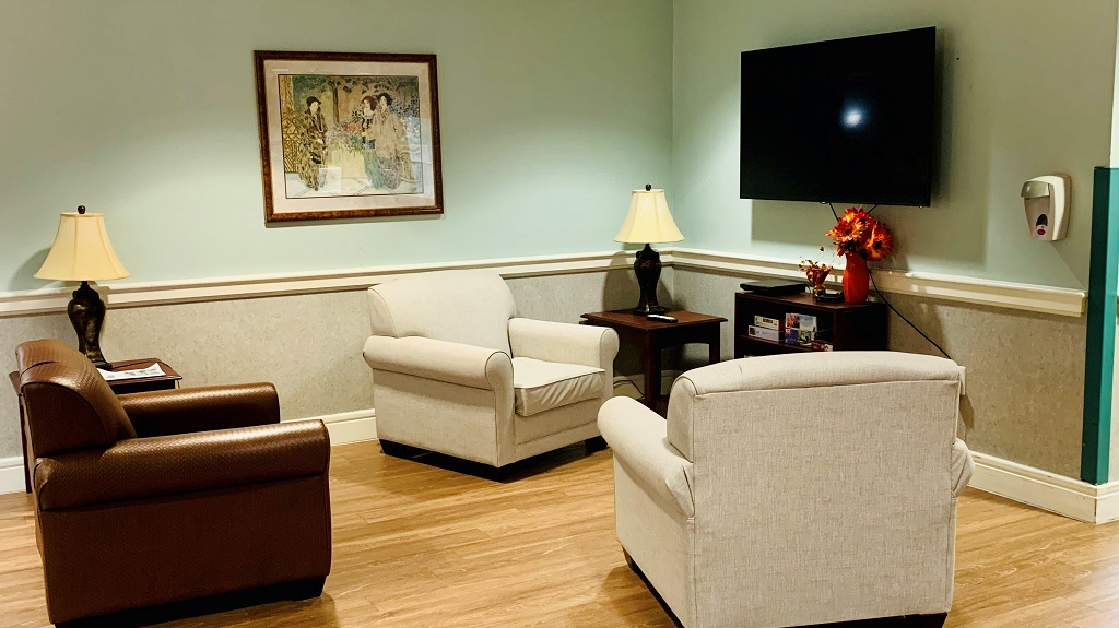 Resident common area in the lobby with chairs and tv.